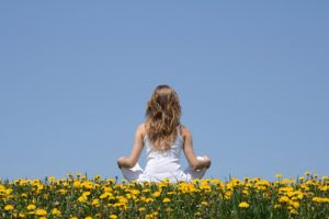 Woman Sitting on Field of Flowers