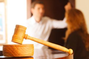 Couple Arguing Behind Wooden Gavel